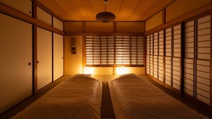 A traditional Japanese-style room with tatami flooring, sliding doors, and a low ceiling with a hanging light fixture. - GrandTree Hakone Sengokuhara (Hakone)