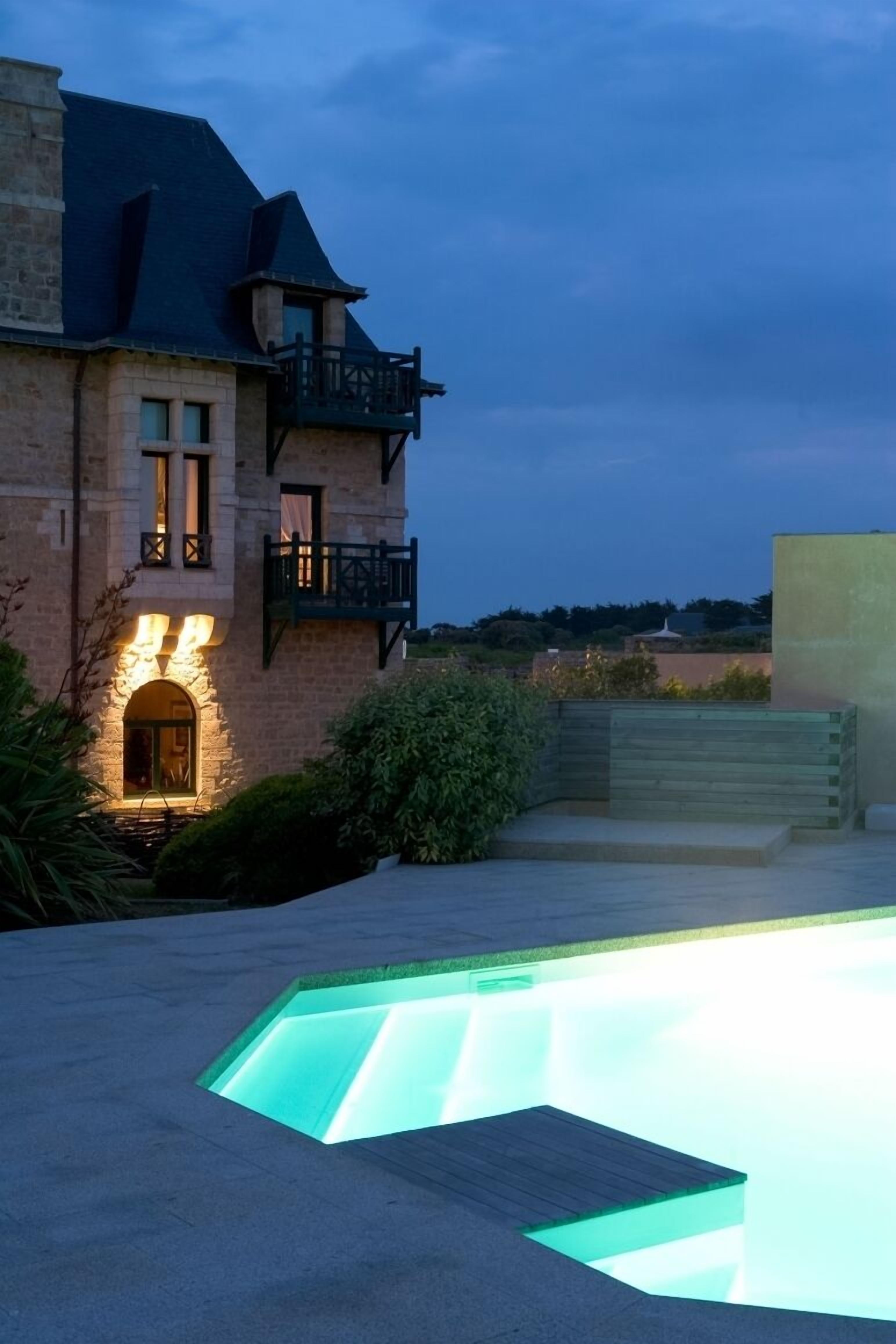 Vista frontal de la propiedad por la tarde o noche