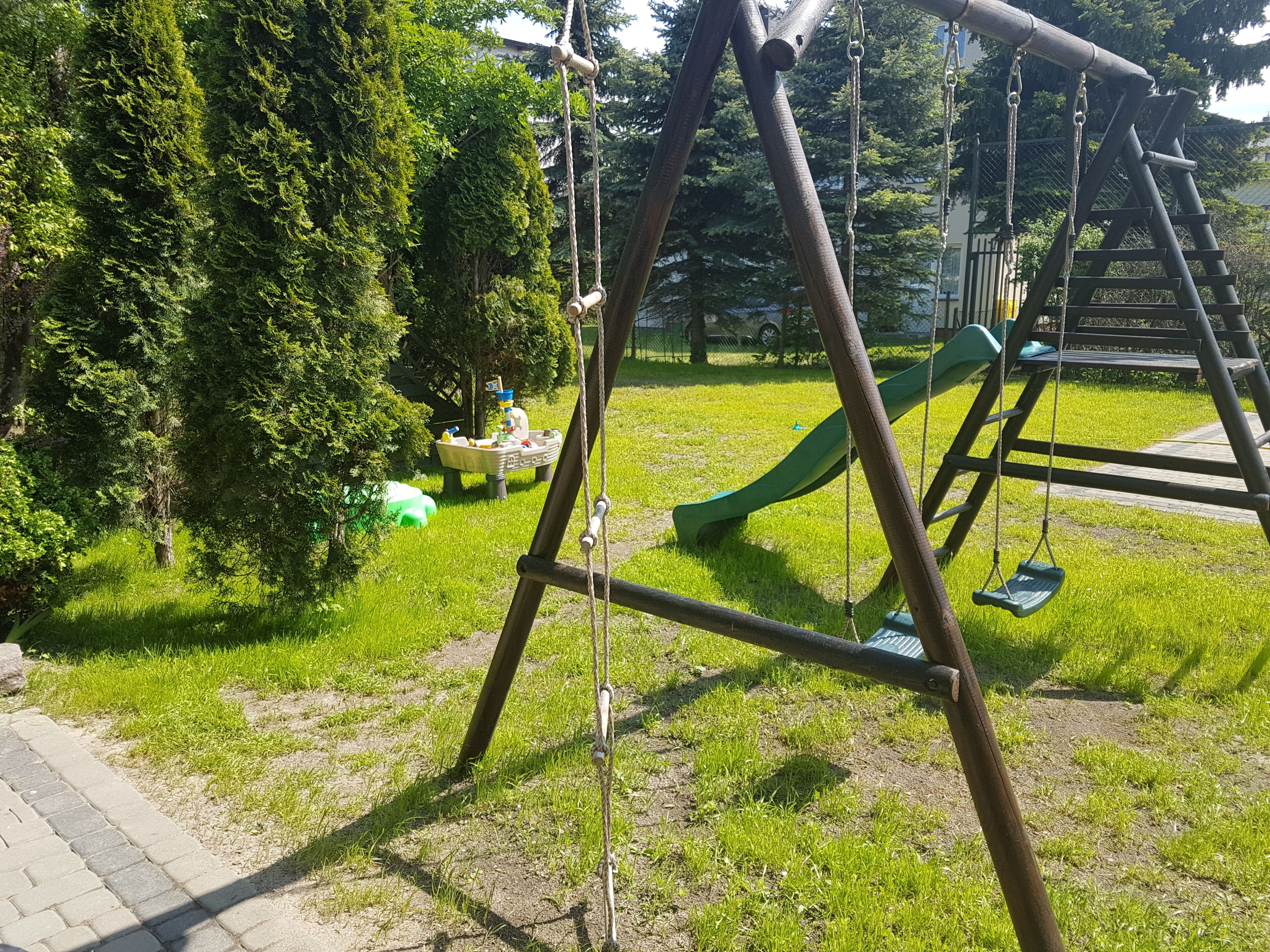 A playground with a swing set and a slide.