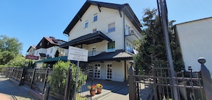 A two-story building with a sign indicating it is an apartment building. There is a reception area with a door and windows. - Dom Wczasowy Barbara (Wladyslawowo)