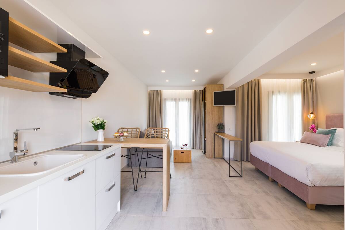 Une chambre d’hôtel moderne équipée d’un lit, d’un bureau, d’une chaise, d’une télévision et d’une salle de bain.