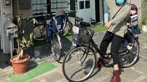Ein Gebäude mit einer grünen Markise, einem Fahrrad davor und einem Blumentopf.