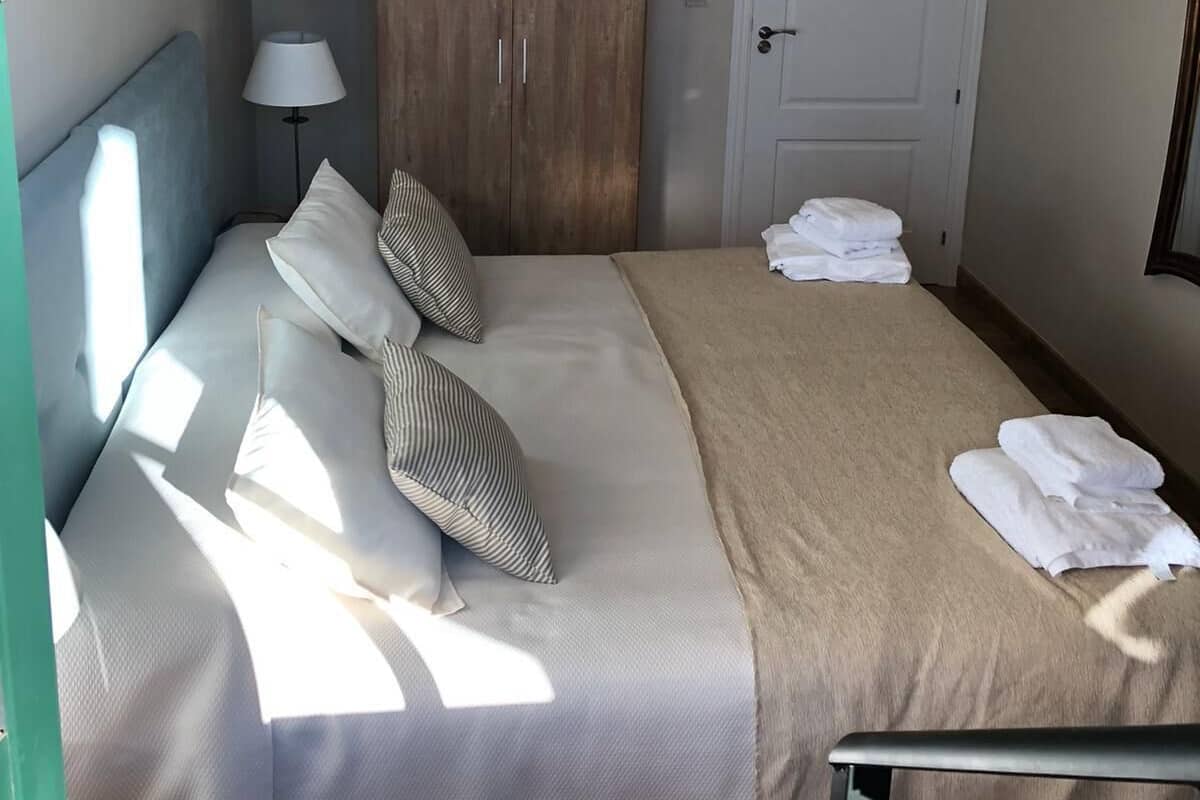 Ein Hotelzimmer mit einem Bett, einem Schrank, einer Tür mit einem Schild und einer Lampe.
