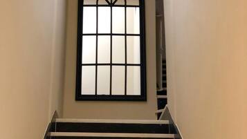Una escalera con peldaños negros y una pared blanca.
