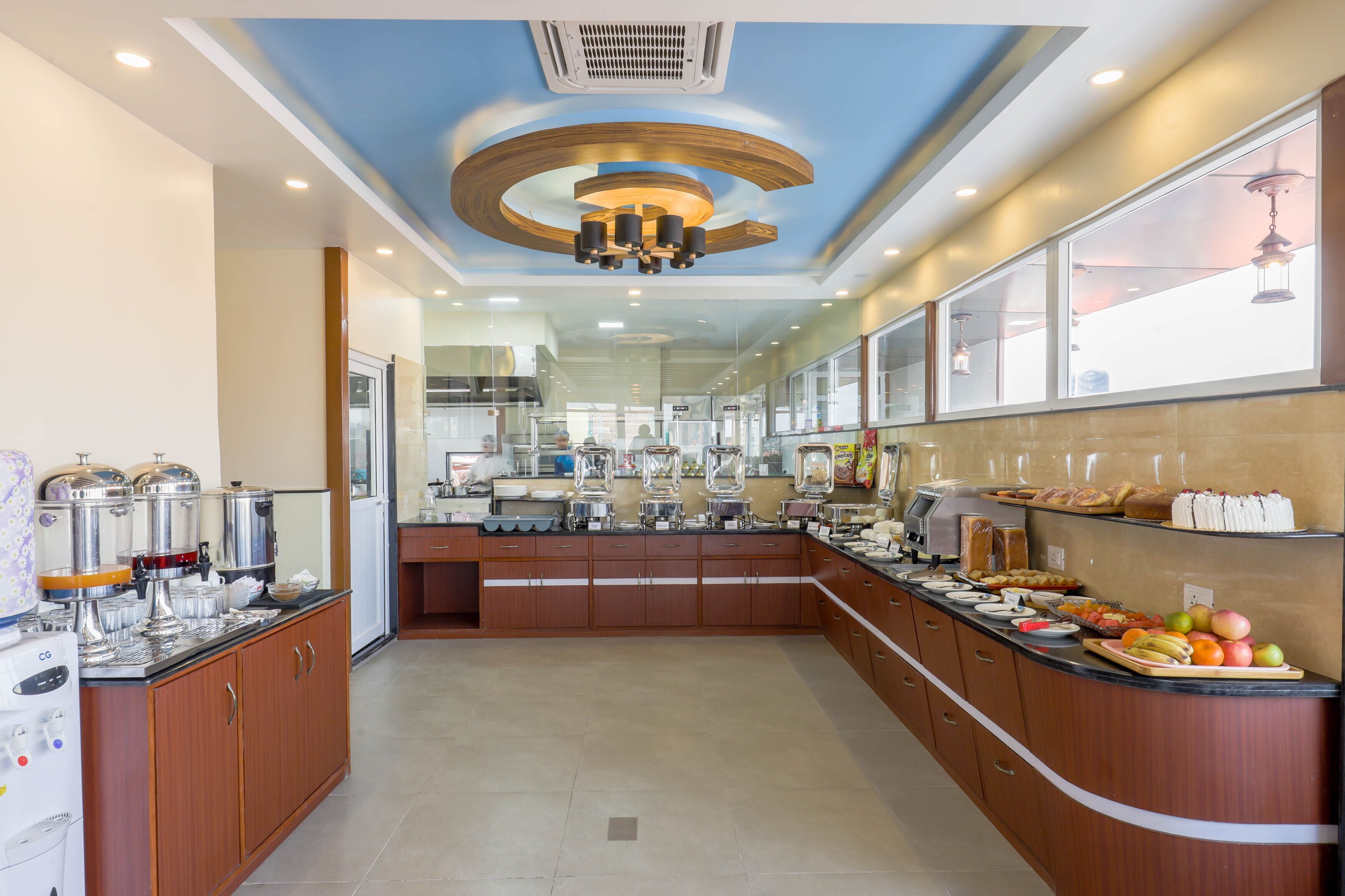 Cozinha moderna com ilha central, equipada com diversos eletrodomésticos e um sistema de buffet.
