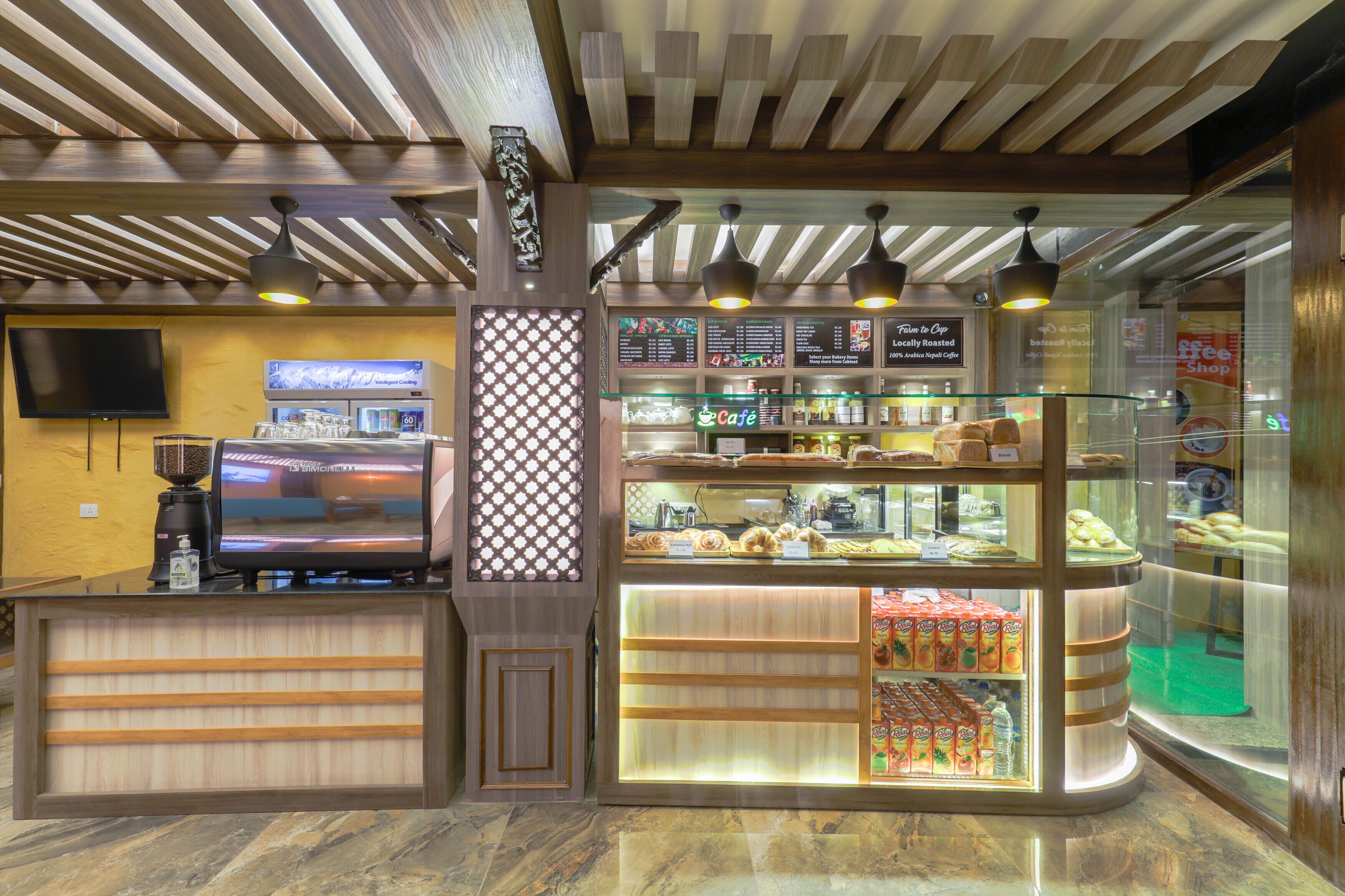 A coffee shop interior with a counter, menu boards, and a display case with baked goods.