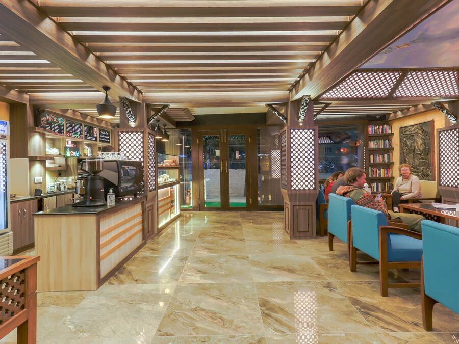 Un restaurante con zona de bar, mesas y vistas a través de puertas de vidrio.