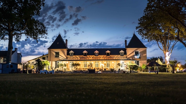 A large, two-story building with a symmetrical roofline, multiple windows, and a central entrance. - Domaine St Ferreol (Chis)