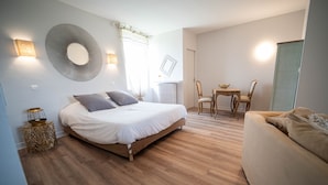 A bedroom with a bed, bedside table, and a small table with chairs. - Domaine St Ferreol (Chis)