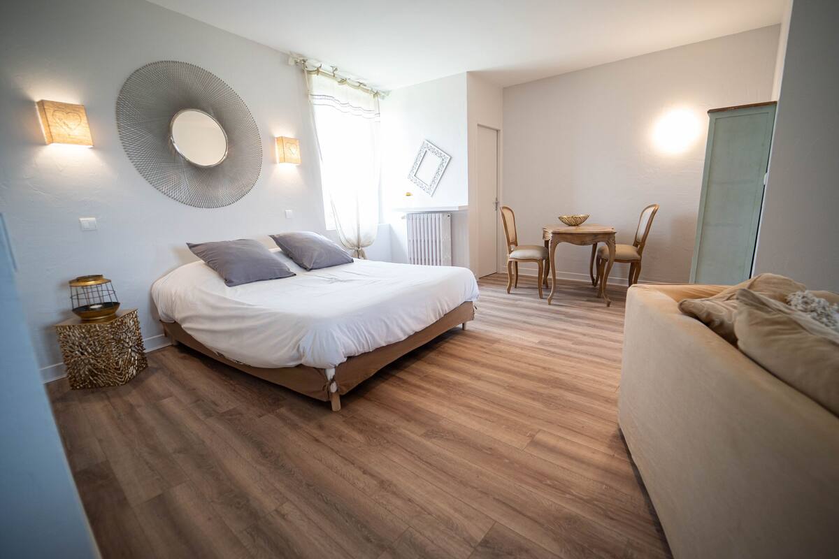 Ein Schlafzimmer mit einem Bett, einem Nachttisch und einem kleinen Tisch mit Stühlen.