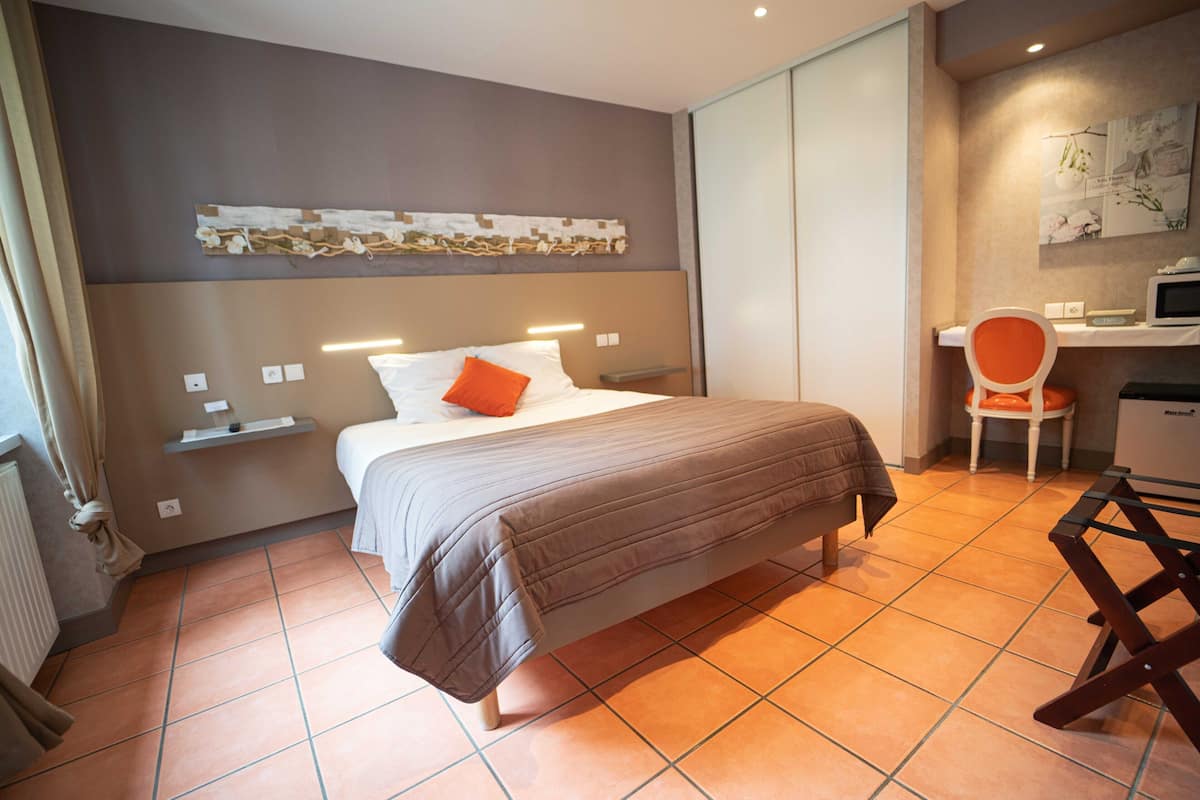 Ein modernes Hotelzimmer mit Bett, Schreibtisch und Stuhl.