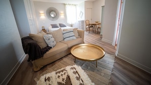 A modern living room with a beige sofa, a round coffee table, and a patterned rug. - Domaine St Ferreol (Chis)