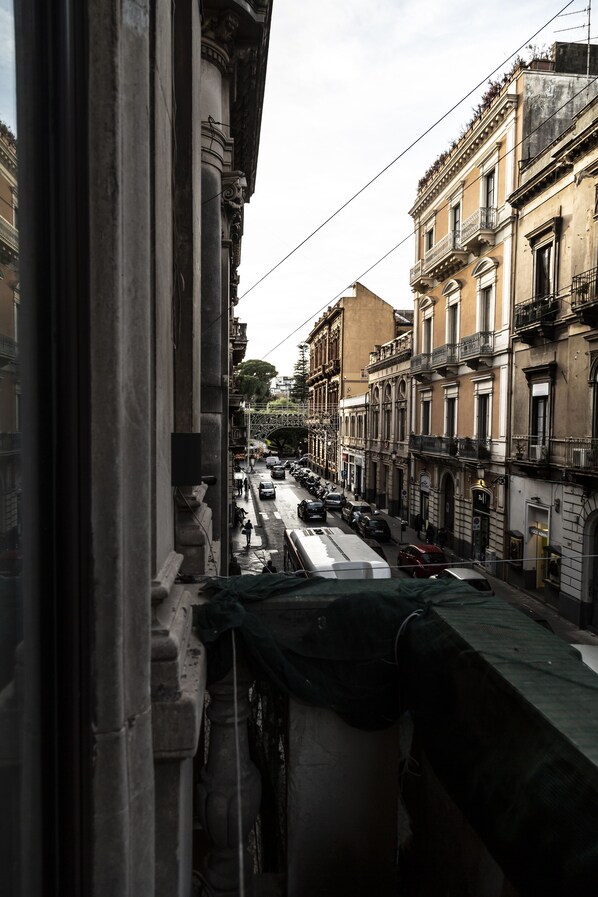 A street view with buildings, a tram, and parked cars. - B&B A casa da Gabry (Catania)