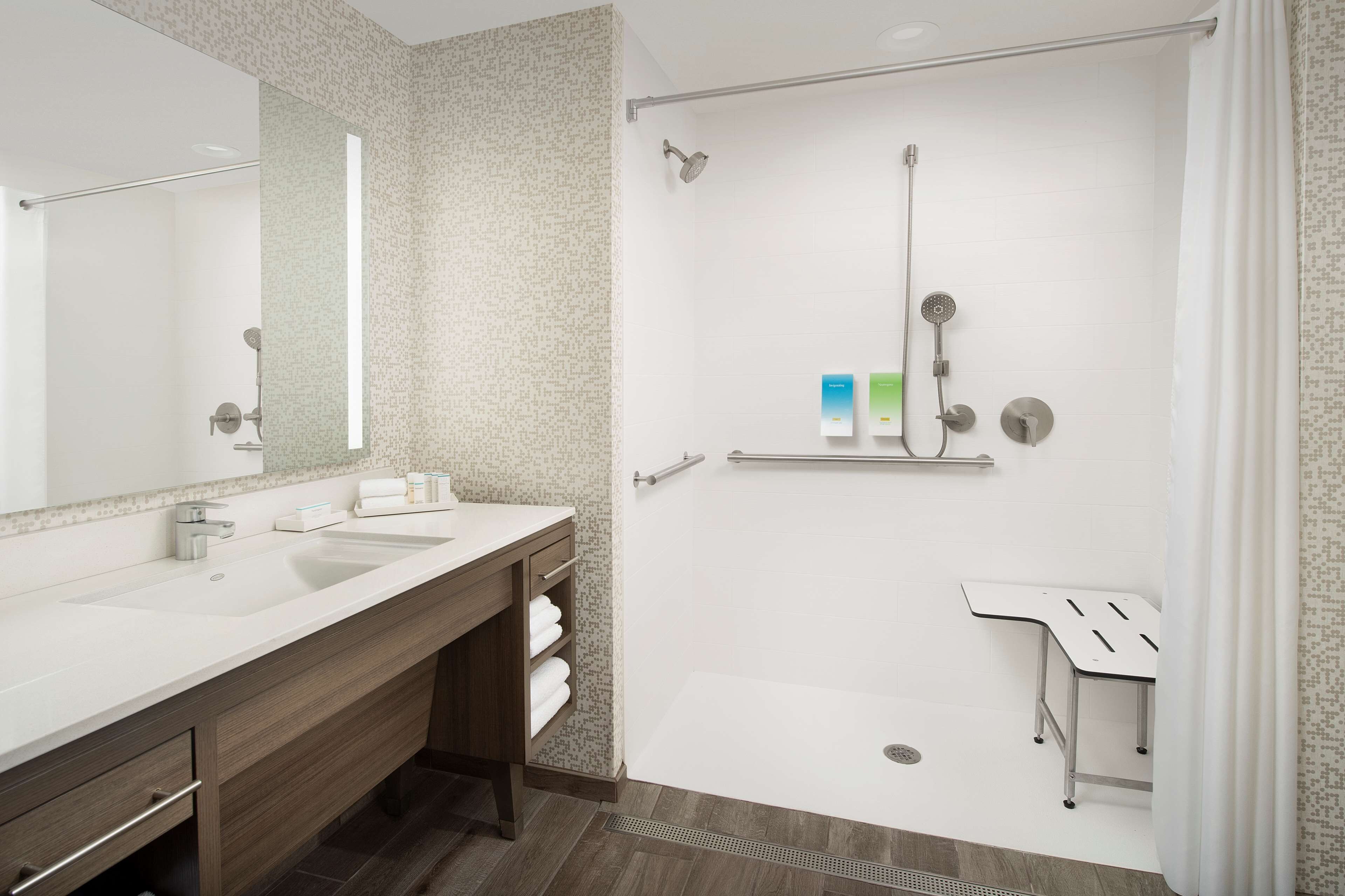Un baño moderno con dos lavamanos, una ducha y un tocador con espejo.