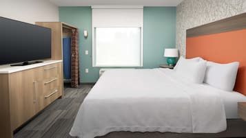 Ein Hotelzimmer mit Bett, Fernseher, Kleiderschrank und Fenster.