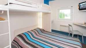 Ein Schlafraum mit Etagenbett, Schreibtisch, Stuhl, Fenster und Fernseher.