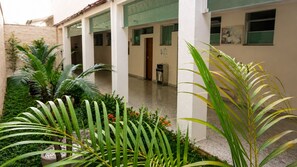 A courtyard with a covered seating area, potted plants, and a water dispenser.