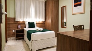 A hotel room with a bed, a nightstand, a desk, and a chair. - Domus Hotel Cidade Nobre – Ipatinga (Ipatinga)