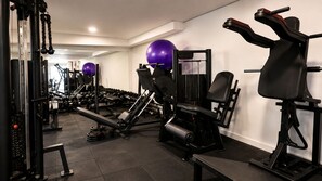 A gym with various exercise equipment, including dumbbells, a bench press, and a leg press. - Domus Hotel Cidade Nobre – Ipatinga (Ipatinga)