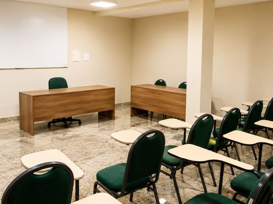 A conference room with two desks, chairs, and a whiteboard.
