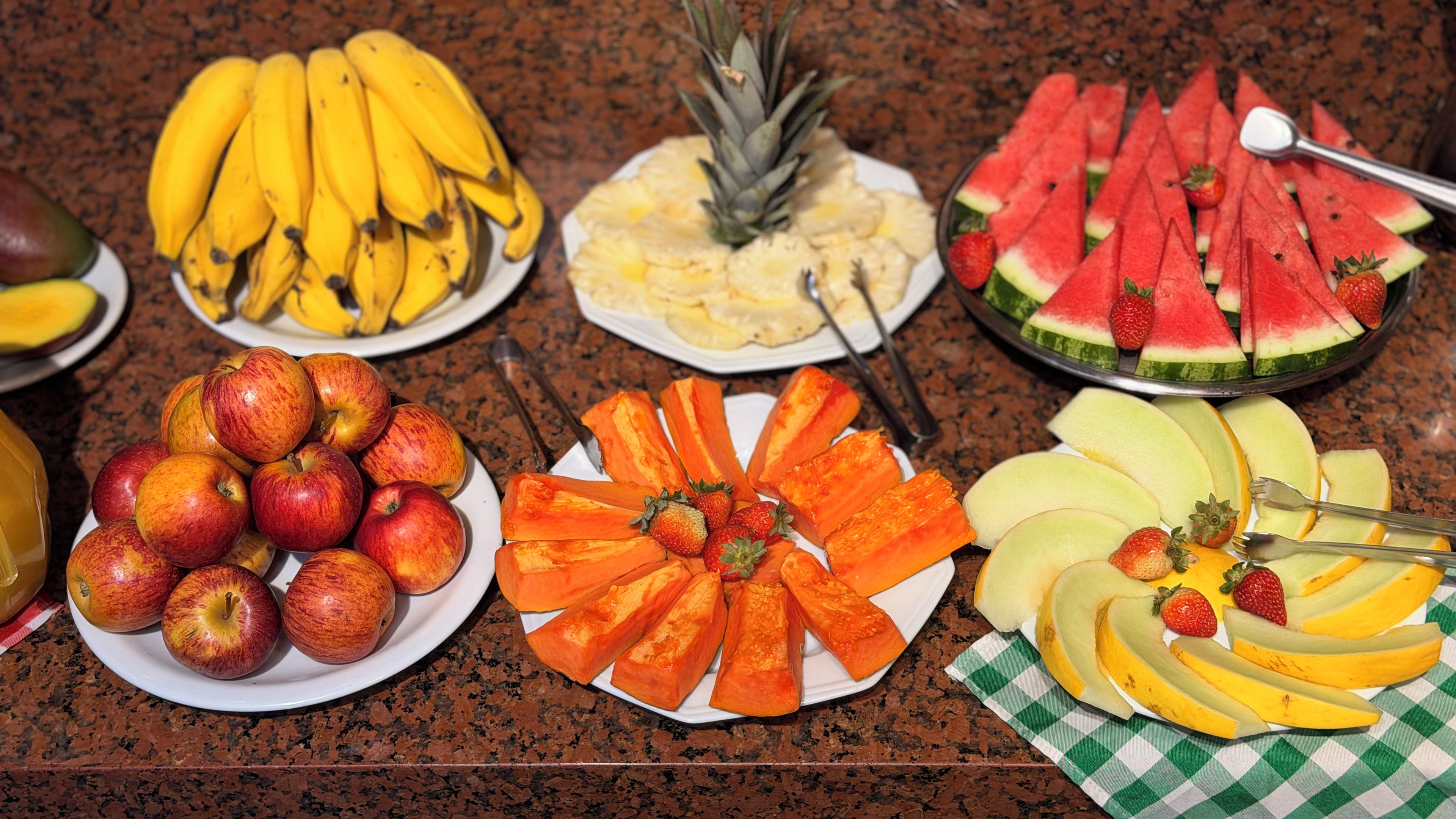 Diversas frutas dispostas sobre uma bancada de granito.