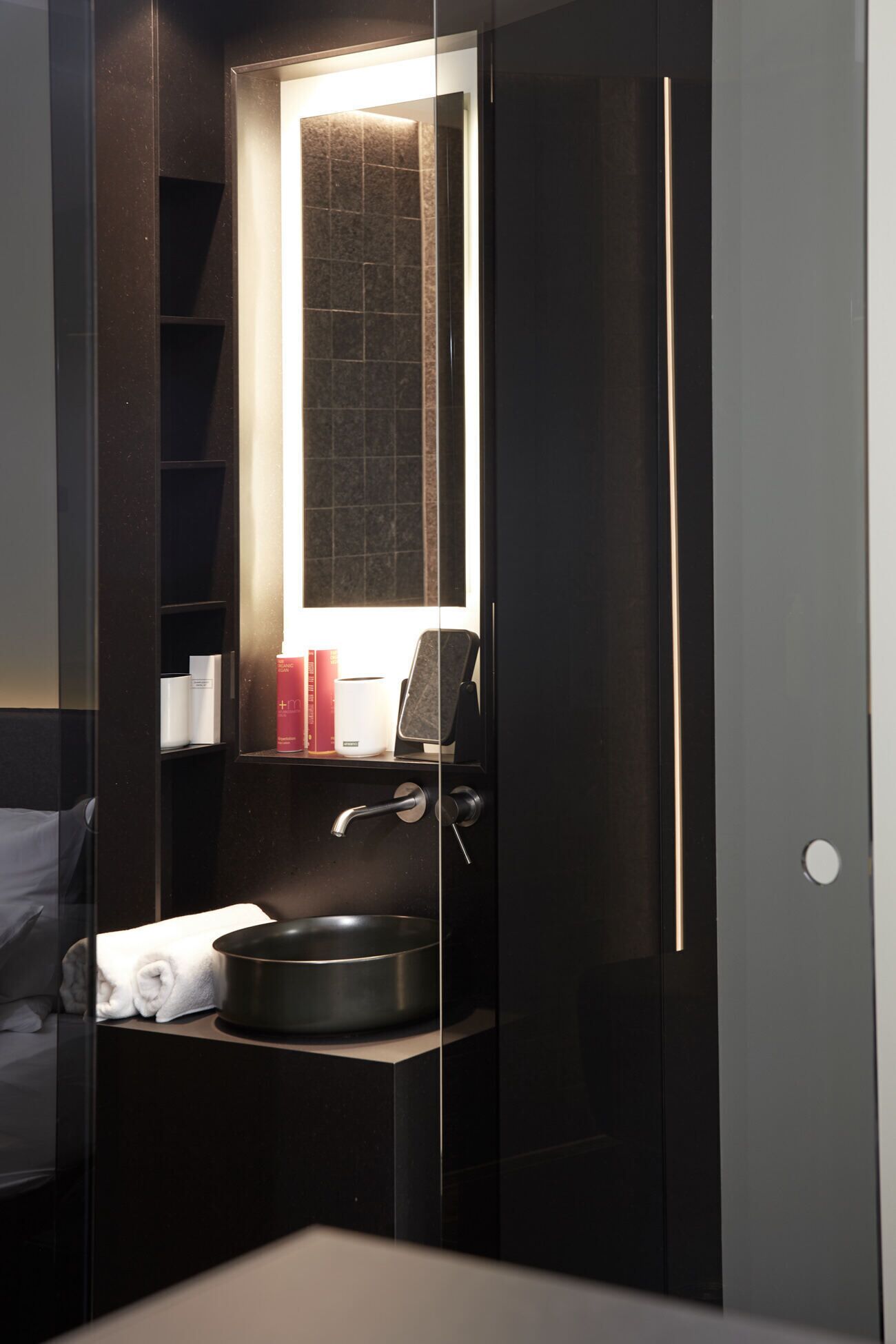 A modern bathroom with a built-in sink, a towel, and a mirror.