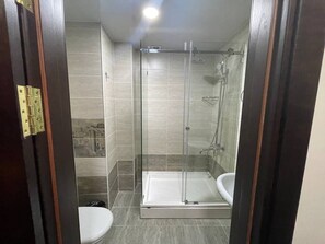 Klassieke driepersoonskamer | Badkamer | Een douche, gratis toiletartikelen, een haardroger, badjassen