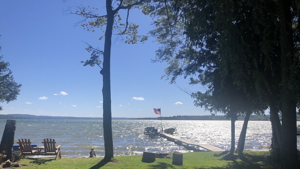 Une vue sur le lac avec un quai, des chaises et une table de pique-nique.