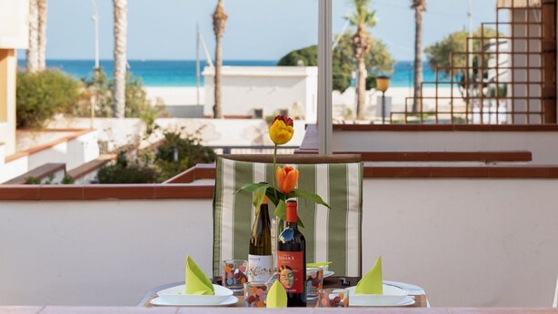 Ein Tisch für zwei Personen mit Blick auf den Strand und das Meer.