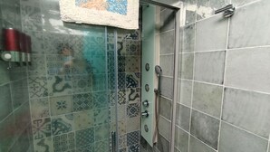 A shower area with patterned tiles and a glass door. - Casas del Castillo de Peñíscola EGVT-498-CS - Deluxe Apartment (Peñíscola)