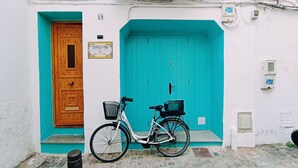 A turquoise door with a wooden panel, a bicycle with a basket, and a sign reading "EPICENTRO". - Casas del Castillo de Peñíscola EGVT-498-CS - Deluxe Apartment (Peñíscola)