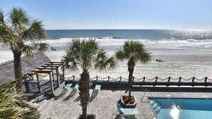 A beach view with a pool area, palm trees, and lounge chairs. - 0209 Waters Edge Resort 1 Bedroom Condo by RedAwning (Murrells Inlet)