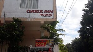 A building with a sign for Oasis Inn Rooms. - Oasis Inn (Negombo)