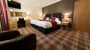 Une chambre d’hôtel avec un lit double, un bureau avec une chaise, une télévision et une armoire.