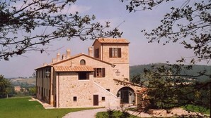 A stone building with a tower, a staircase, and a door. - Agriturismo Chieteno (Cetona)