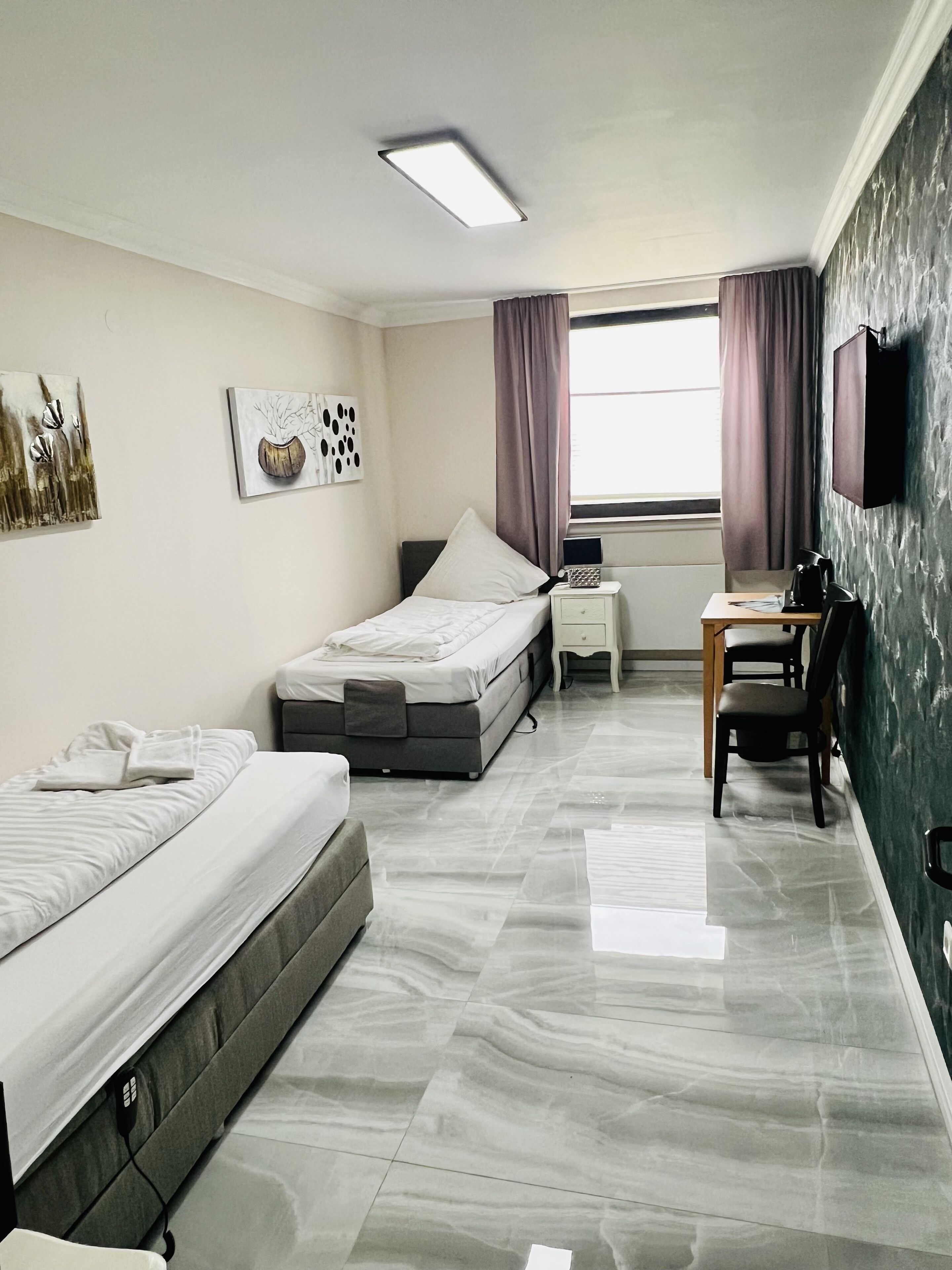 Un dormitorio moderno con dos camas, un escritorio y una silla.