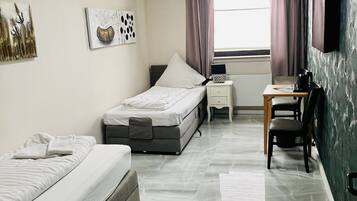 Un dormitorio moderno con dos camas, un escritorio y una silla.