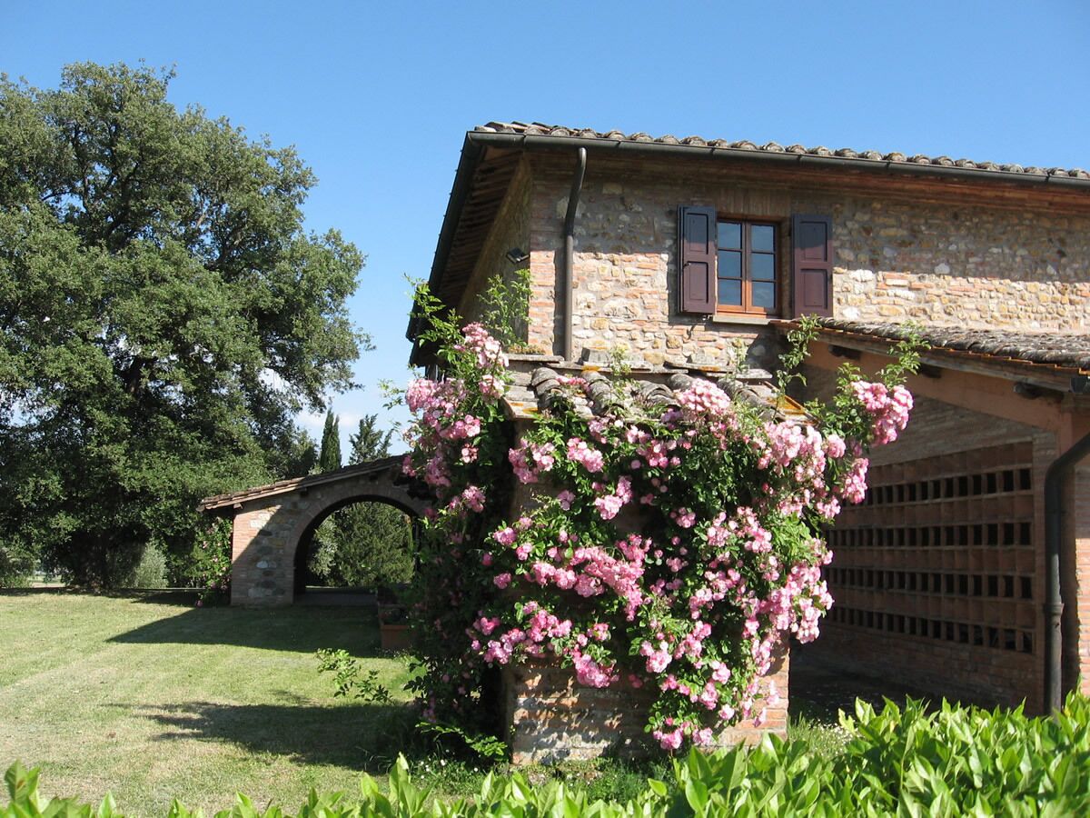 Una casa in pietra con un arco in mattoni e un garage.