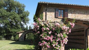 Una casa in pietra con un arco in mattoni e un garage.
