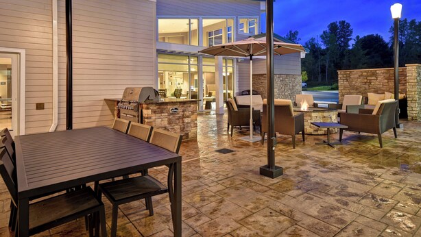 An outdoor patio with a dining table and chairs, a barbecue grill, and a fire pit. - Residence Inn by Marriott Middletown Goshen (Middletown)