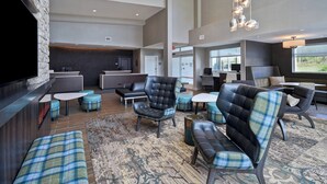 A spacious lobby with modern seating, a stone accent wall, and large windows offering views. - Residence Inn by Marriott Middletown Goshen (Middletown)