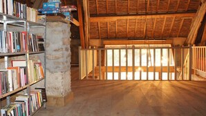 A rustic library with bookshelves and a wooden ceiling. - Domaine Bonneblond - Tentes Glamping (Saint-Désiré)