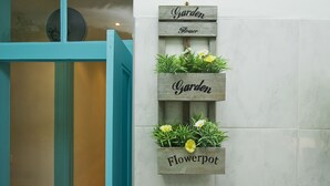 A vertical wooden planter with the words "Garden" and "Flowerpot" on it, containing white and yellow flowers. - C&O Guest House Alcântara-Lisbon (Lisbon)