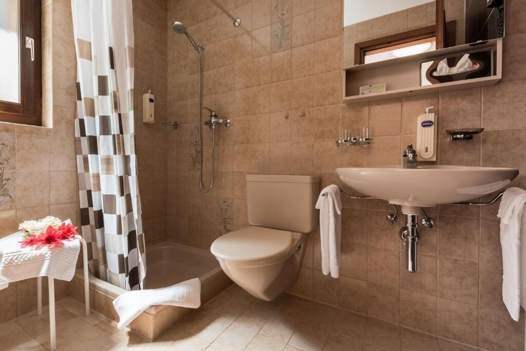 A bathroom with a shower, toilet, and sink.