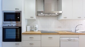 A modern kitchen with a built-in oven, microwave, coffee maker, and dishwasher.