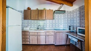 A compact kitchen with wooden cabinets, a sink, and a microwave. - Rural Apartment Lledoner de Son Amer (Felanitx)