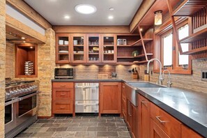 A modern kitchen with wooden cabinets, a stainless steel range, and a built-in dishwasher.