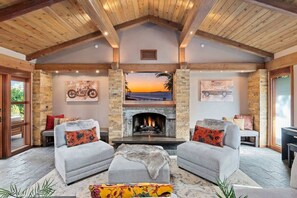 A cozy living room with a fireplace, two sofas, and a view of the outdoors.