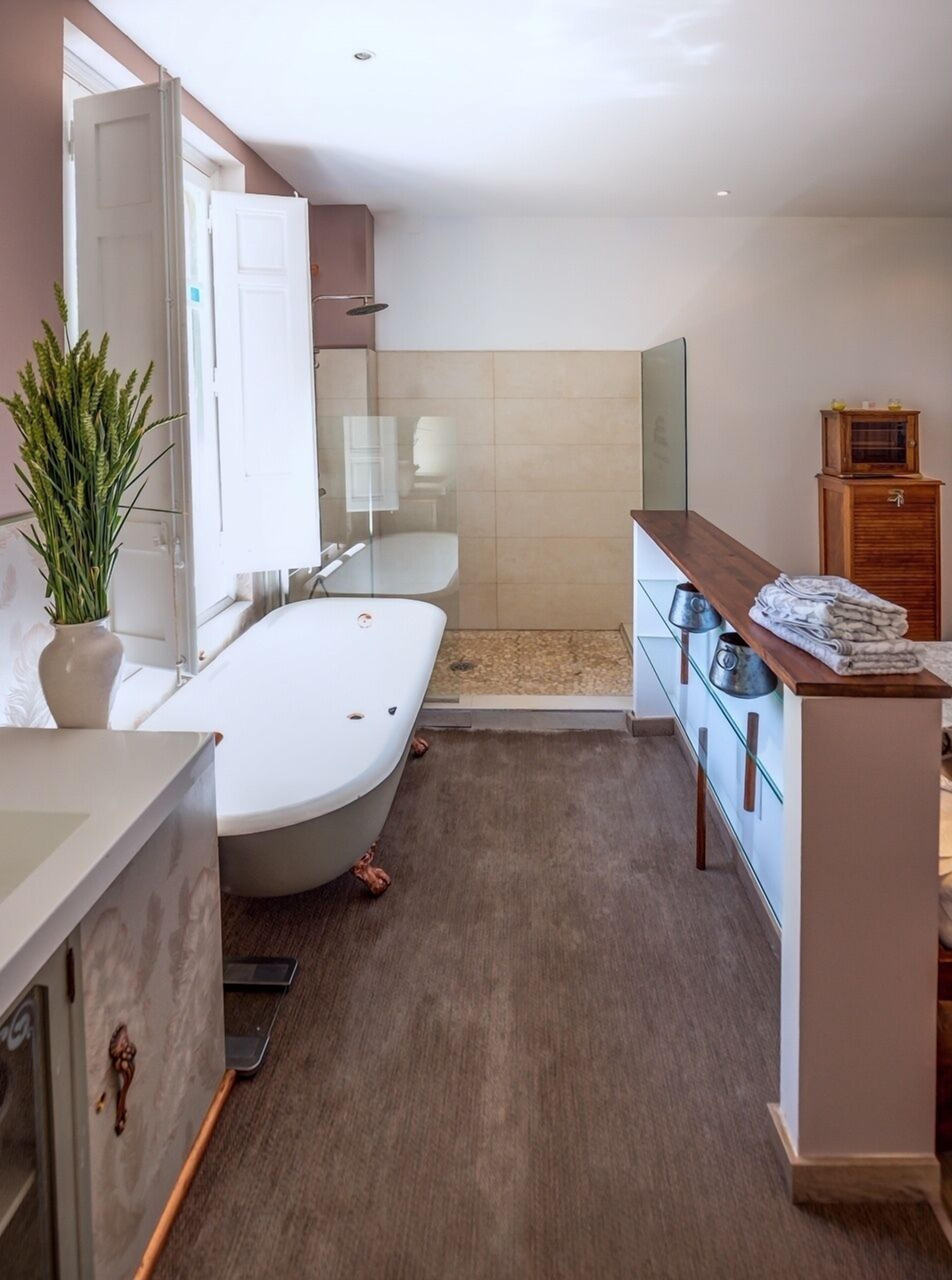A modern bathroom with a bathtub, a shower, and a vanity with a mirror.