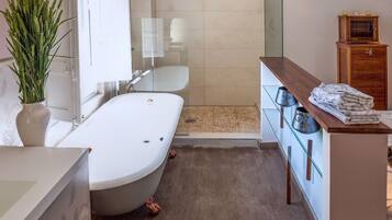 A modern bathroom with a bathtub, a shower, and a vanity with a mirror.